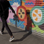 Man casting a shade in a colourful wall in Brixton,London,UK